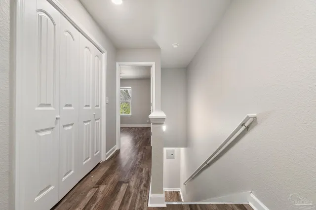 a view of a hallway with wooden floor and staircase