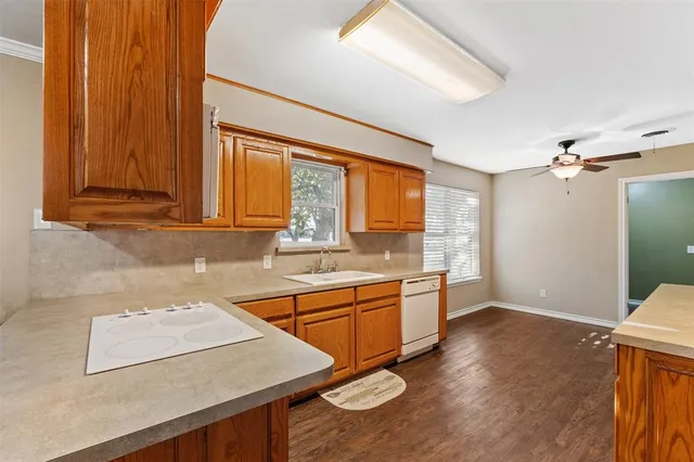 a kitchen with stainless steel appliances granite countertop a sink a stove and a wooden floors