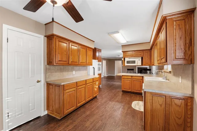 a kitchen with a sink cabinets stainless steel appliances and a large window
