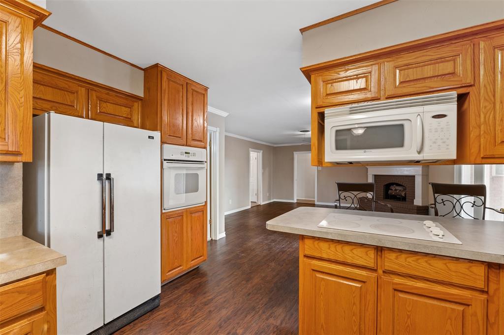 913 North Main Street Springtown, TX 76082 - Photo 17 of 40 a kitchen with stainless steel appliances granite countertop a refrigerator a stove and a wooden cabinets