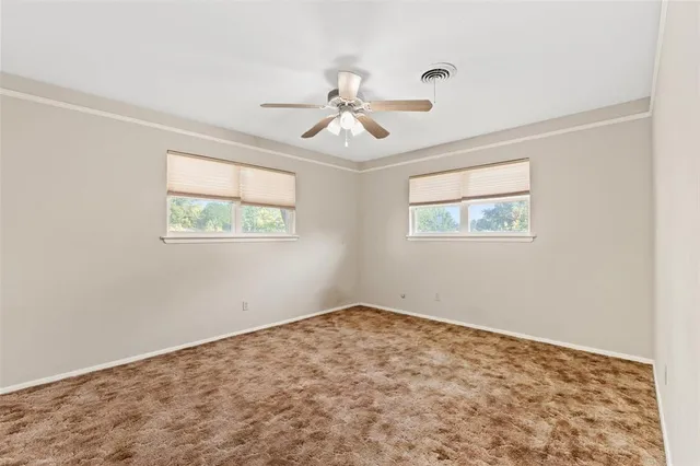 a view of a big room with wooden floor and windows