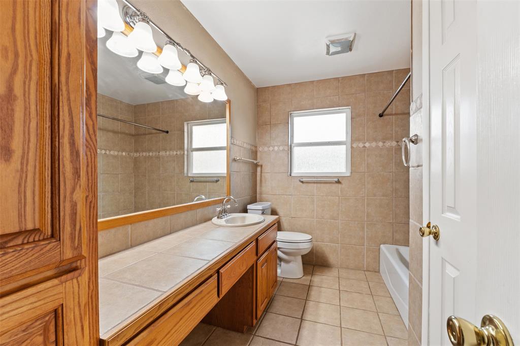 913 North Main Street Springtown, TX 76082 - Photo 28 of 40 a bathroom with a sink a toilet and a mirror