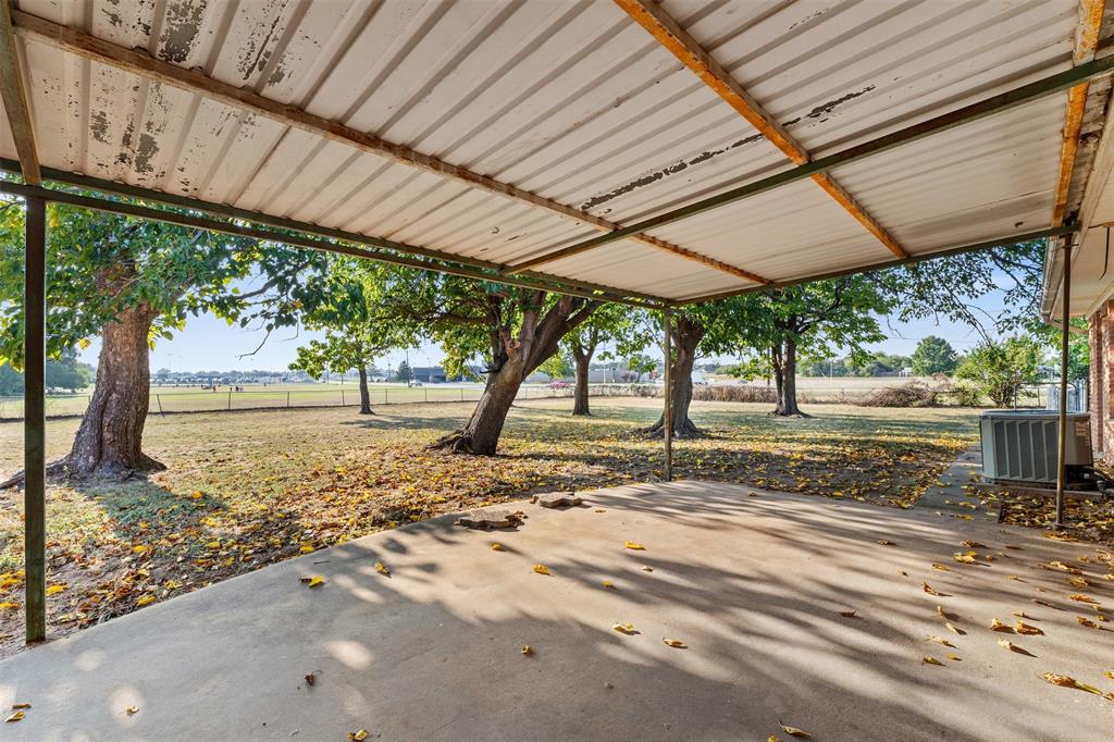 913 North Main Street Springtown, TX 76082 - Photo 32 of 40 a view of a yard with table and chairs under an umbrella