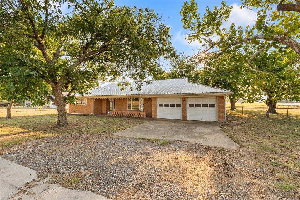 913 North Main Street Springtown, TX 76082 - Photo 4 of 40 a front view of a house with a garden