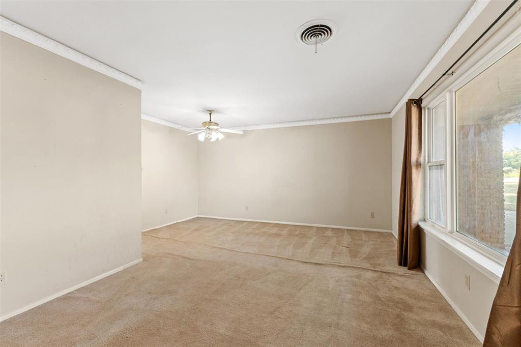 913 North Main Street Springtown, TX 76082 - Photo 9 of 40 an empty room with a windows and ceiling fan