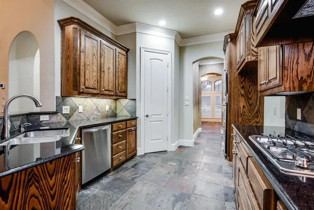 a kitchen with stainless steel appliances granite countertop a stove a sink and a microwave
