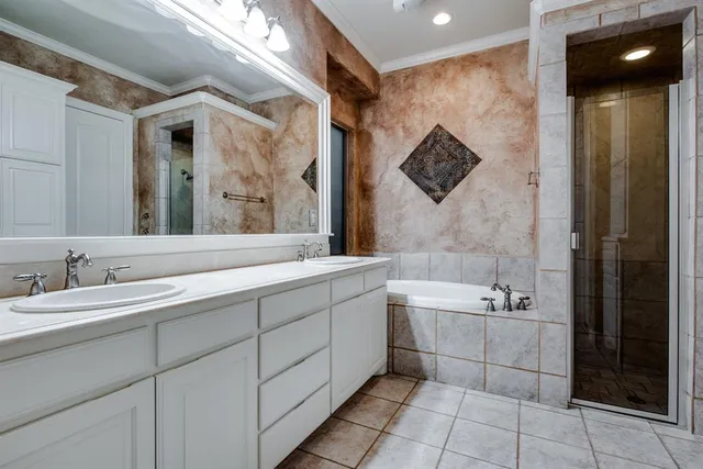a spacious bathroom with a double vanity sink a mirror and a bathtub