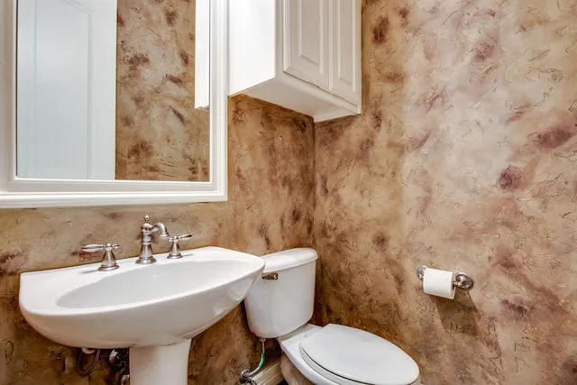 a bathroom with a sink a toilet and mirror
