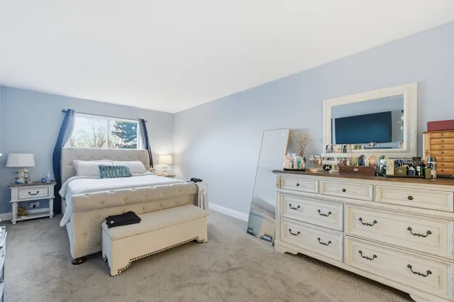 a bedroom with a bed a dresser and a mirror