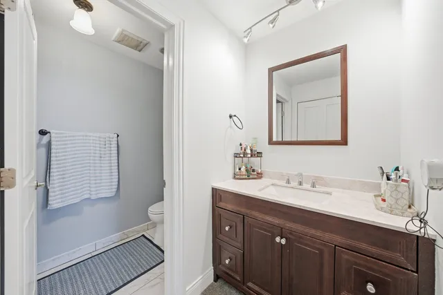 a bathroom with a sink a toilet and a mirror