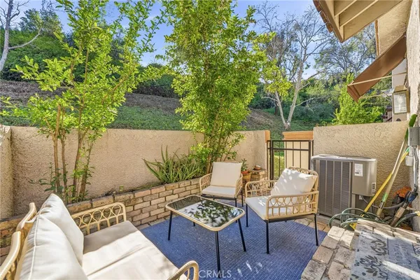 a view of a chairs and table in the back yard of the house