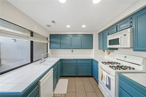 a kitchen with stainless steel appliances a sink stove and cabinets