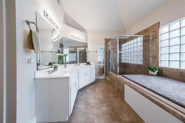 a large bathroom with a granite countertop double vanity sink and mirror