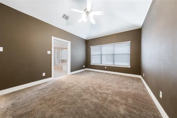 an empty room with windows and ceiling fan