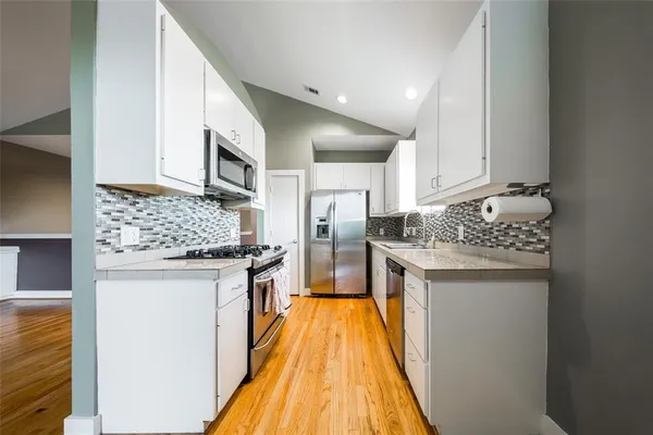 a kitchen with stainless steel appliances granite countertop a stove and a refrigerator