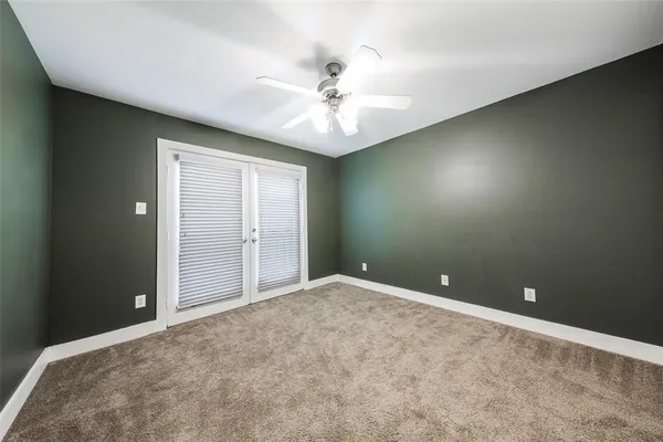 an empty room and chandelier fan