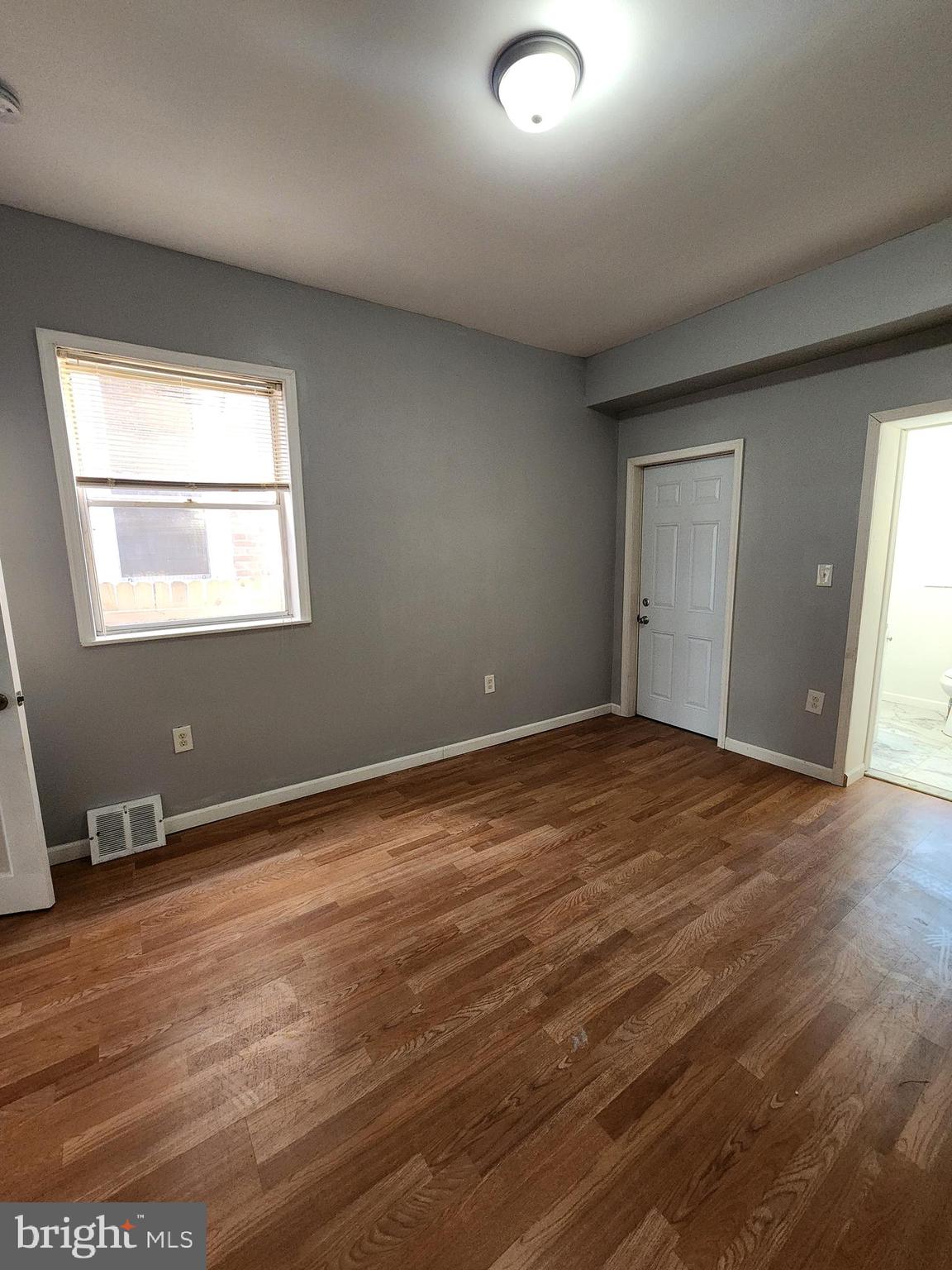 6616 Leeds Street Philadelphia, PA 19151 - Photo 11 of 29 an empty room with wooden floor and windows