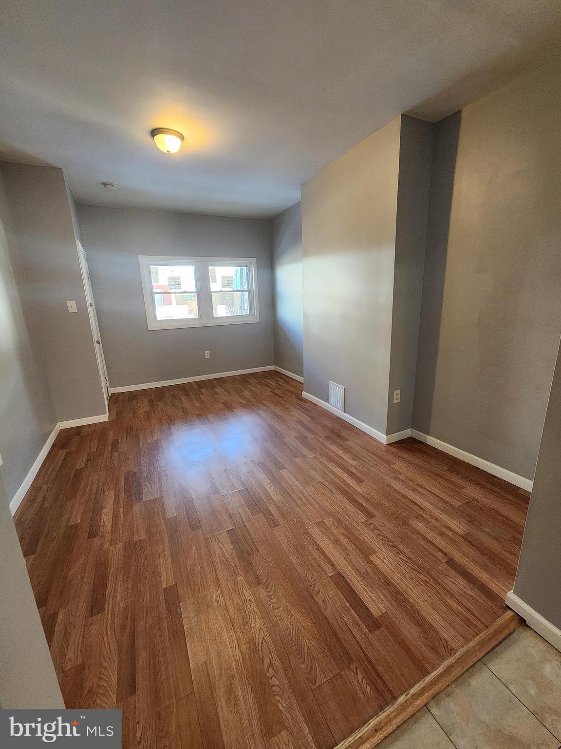 6616 Leeds Street Philadelphia, PA 19151 - Photo 4 of 29 an empty room with wooden floor and windows