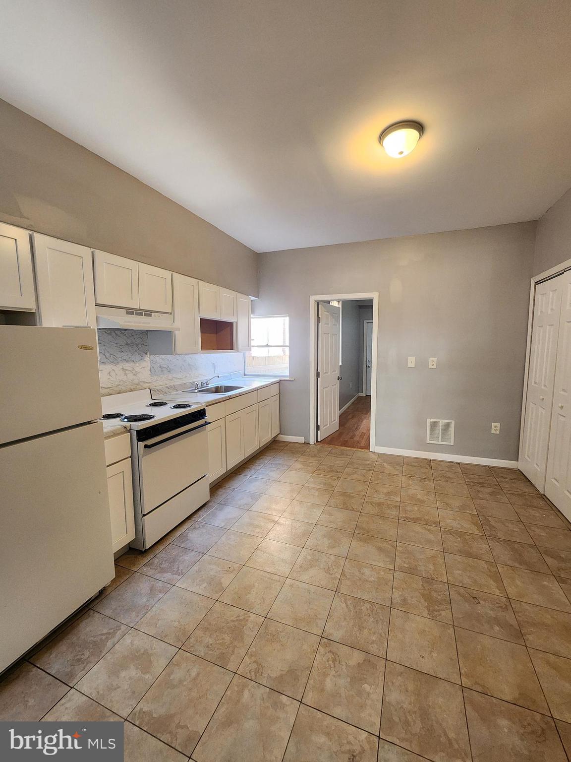 6616 Leeds Street Philadelphia, PA 19151 - Photo 5 of 29 a kitchen with stainless steel appliances granite countertop a stove a sink and a refrigerator