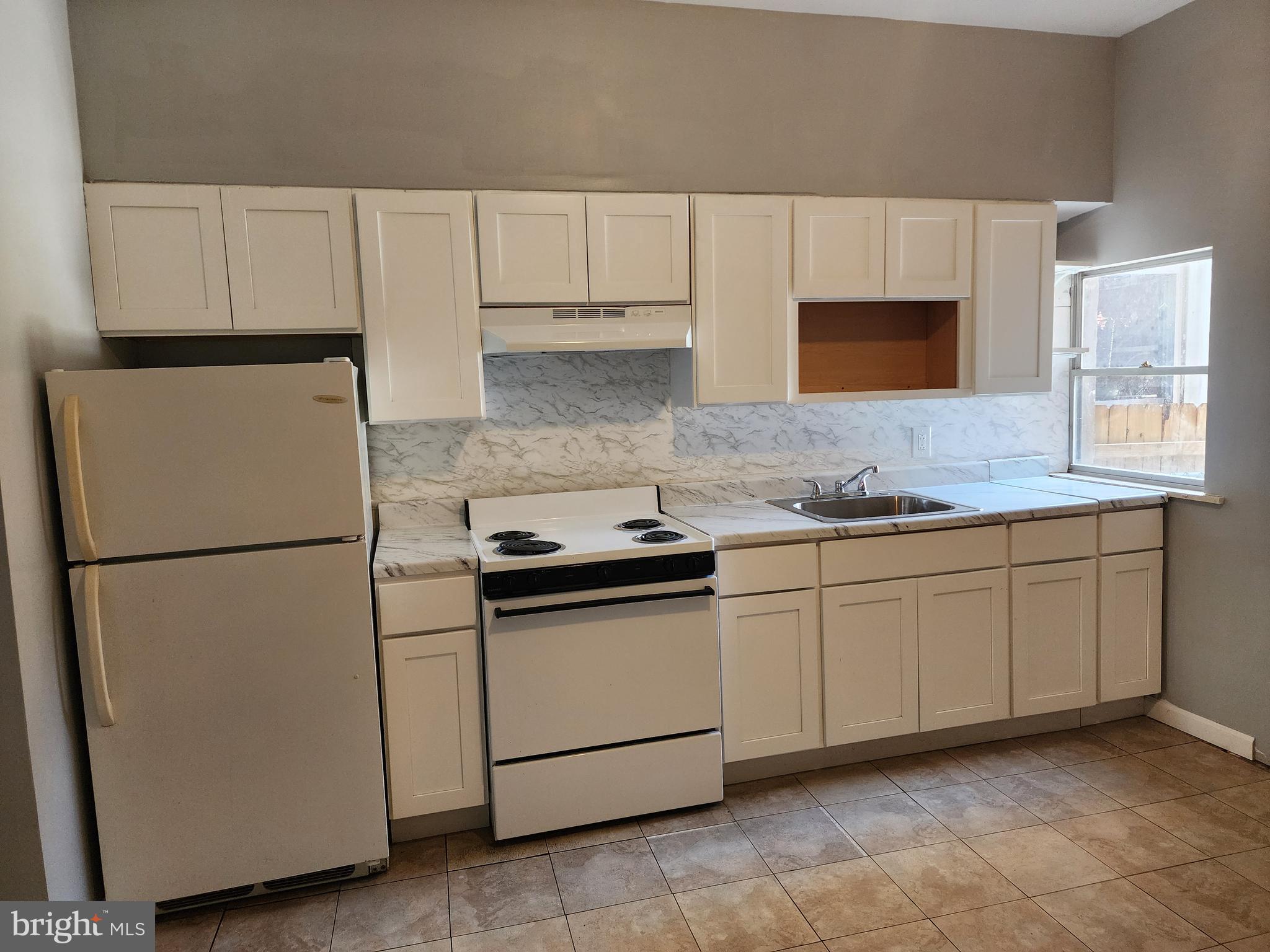 6616 Leeds Street Philadelphia, PA 19151 - Photo 6 of 29 a kitchen with granite countertop cabinets and white appliances