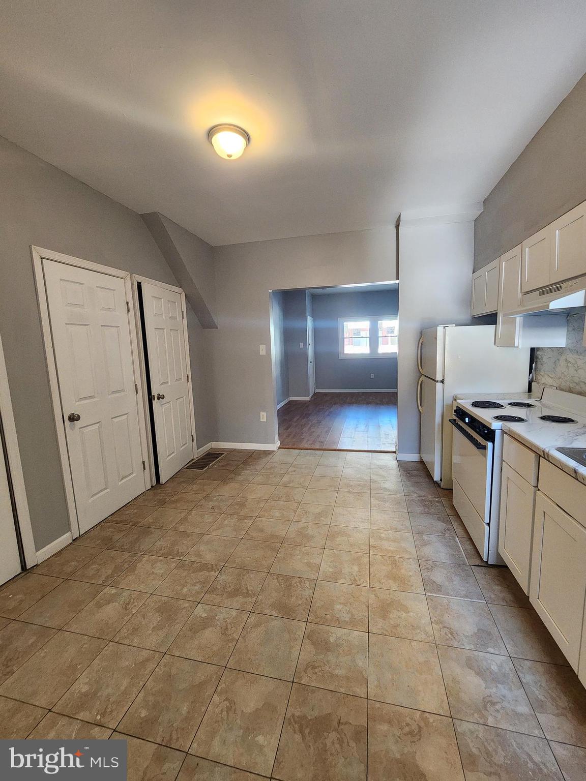 6616 Leeds Street Philadelphia, PA 19151 - Photo 8 of 29 a large hall with stainless steel appliances granite countertop a stove a sink and a refrigerator