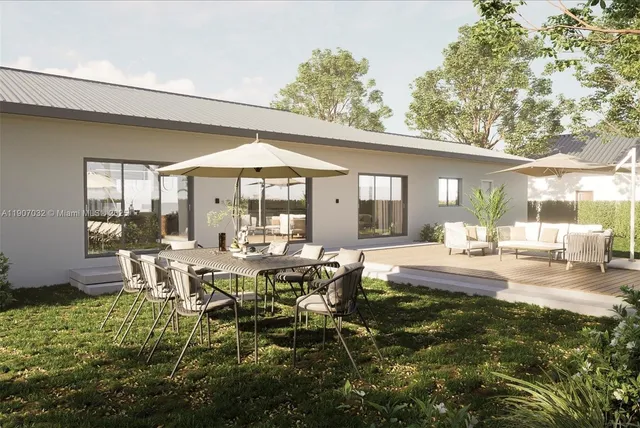 a view of a house with backyard and sitting area
