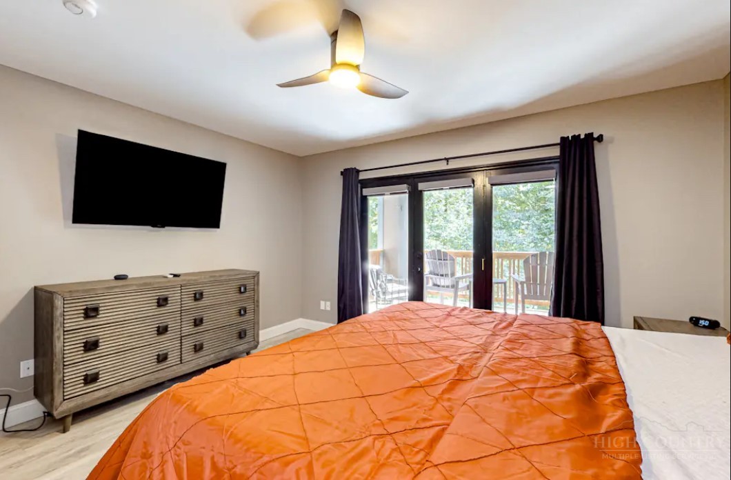 190 Still Lake Drive, Unit 321 Boone, NC 28607 - Photo 13 of 30 a bedroom with a large bed and a flat screen tv