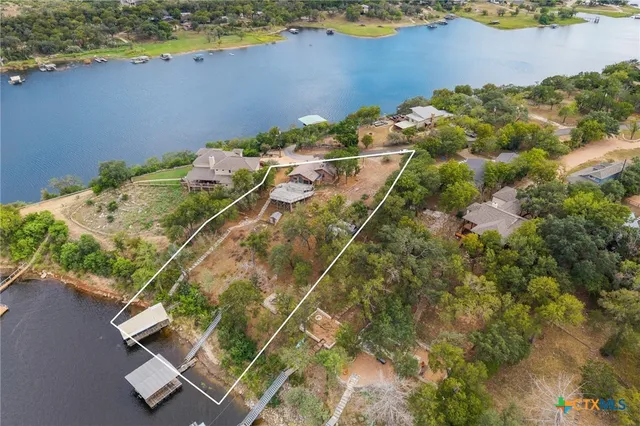 an aerial view of a house with a yard and lake view