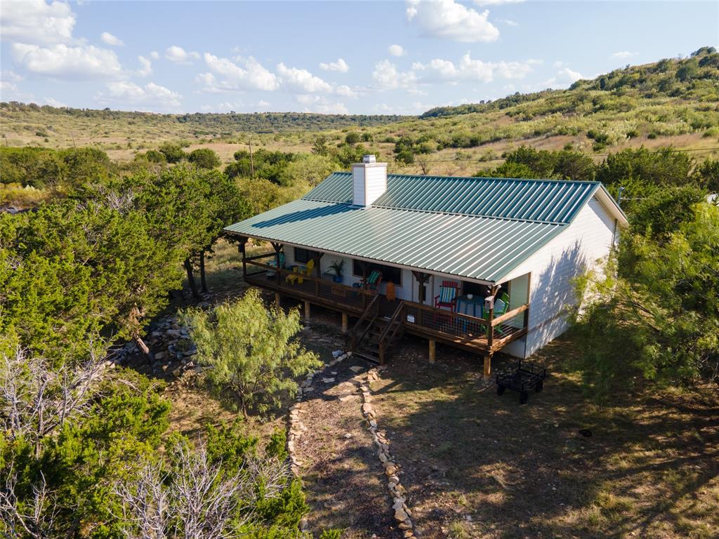 3500 Hog Bend, Unit 135 Graford, TX 76449 - Photo 11 of 34 a terrace with a table and chairs under an umbrella next to a yard