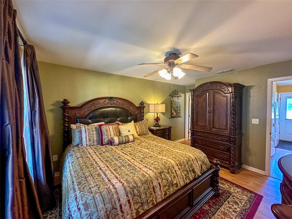 3500 Hog Bend, Unit 135 Graford, TX 76449 - Photo 19 of 34 a bedroom with a bed and a chandelier