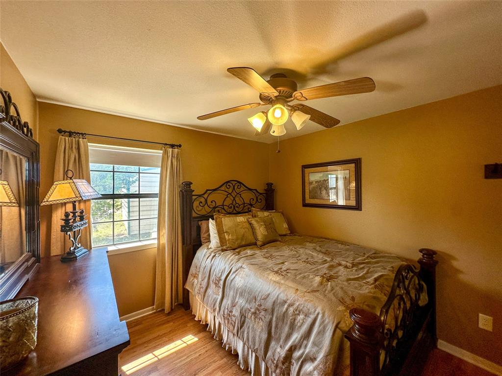 3500 Hog Bend, Unit 135 Graford, TX 76449 - Photo 21 of 34 a bedroom with a bed and wooden floor