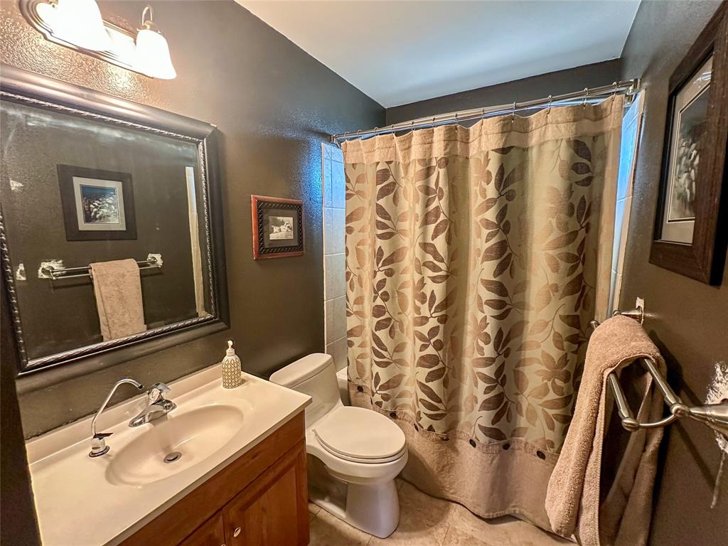 3500 Hog Bend, Unit 135 Graford, TX 76449 - Photo 22 of 34 a bathroom with a sink a toilet and shower