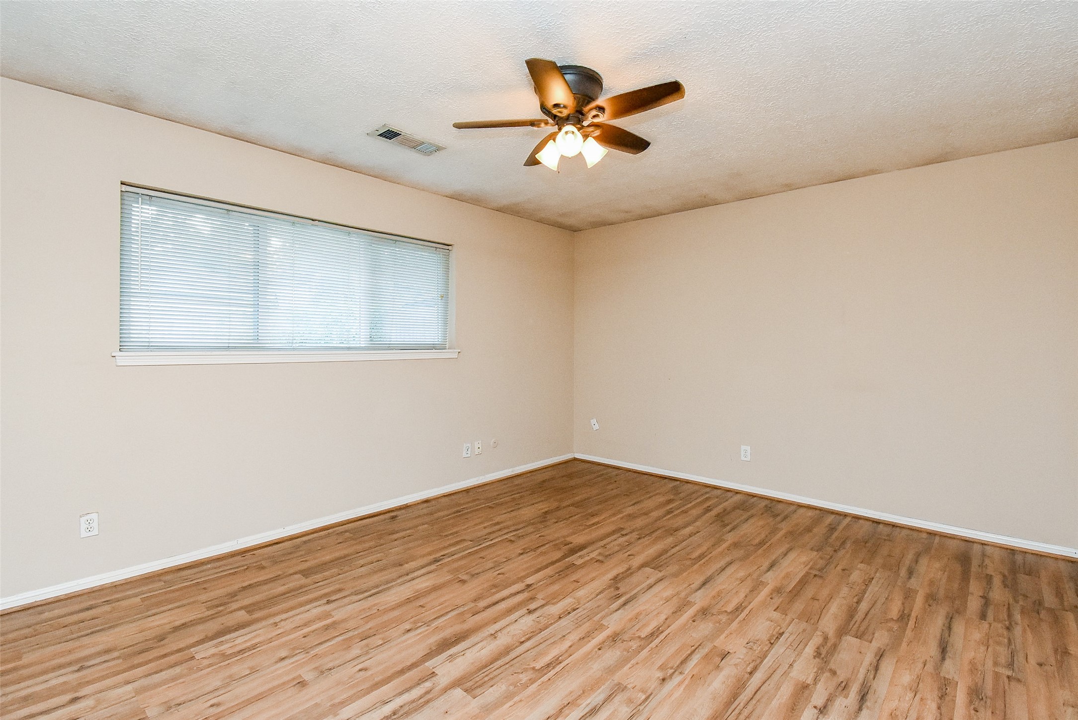 7814 Friars Ct Lane Spring, TX 77379 - Photo 11 of 17 a view of an empty room with wooden floor and a ceiling fan