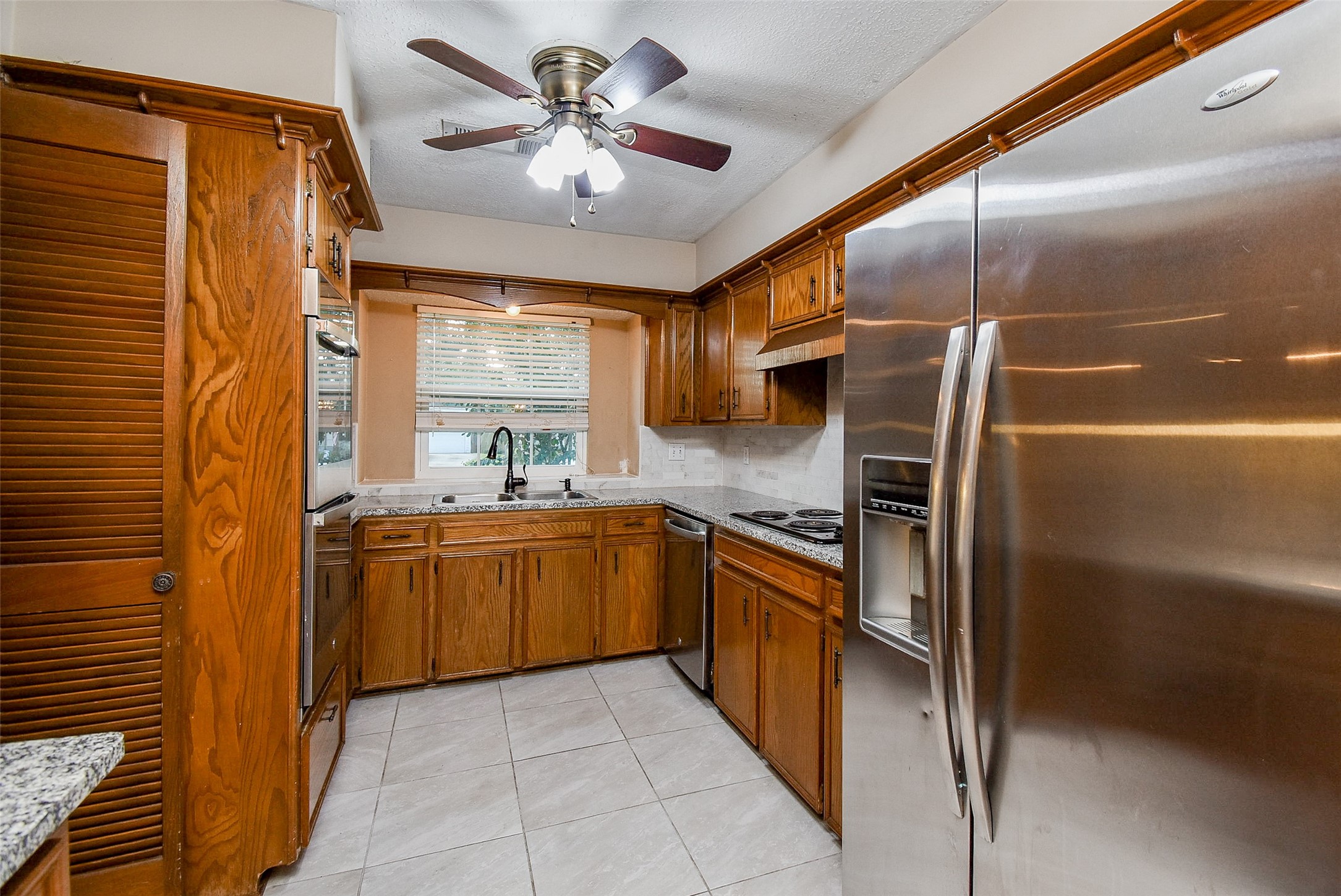 7814 Friars Ct Lane Spring, TX 77379 - Photo 7 of 17 a kitchen with stainless steel appliances granite countertop a refrigerator a sink a stove and island