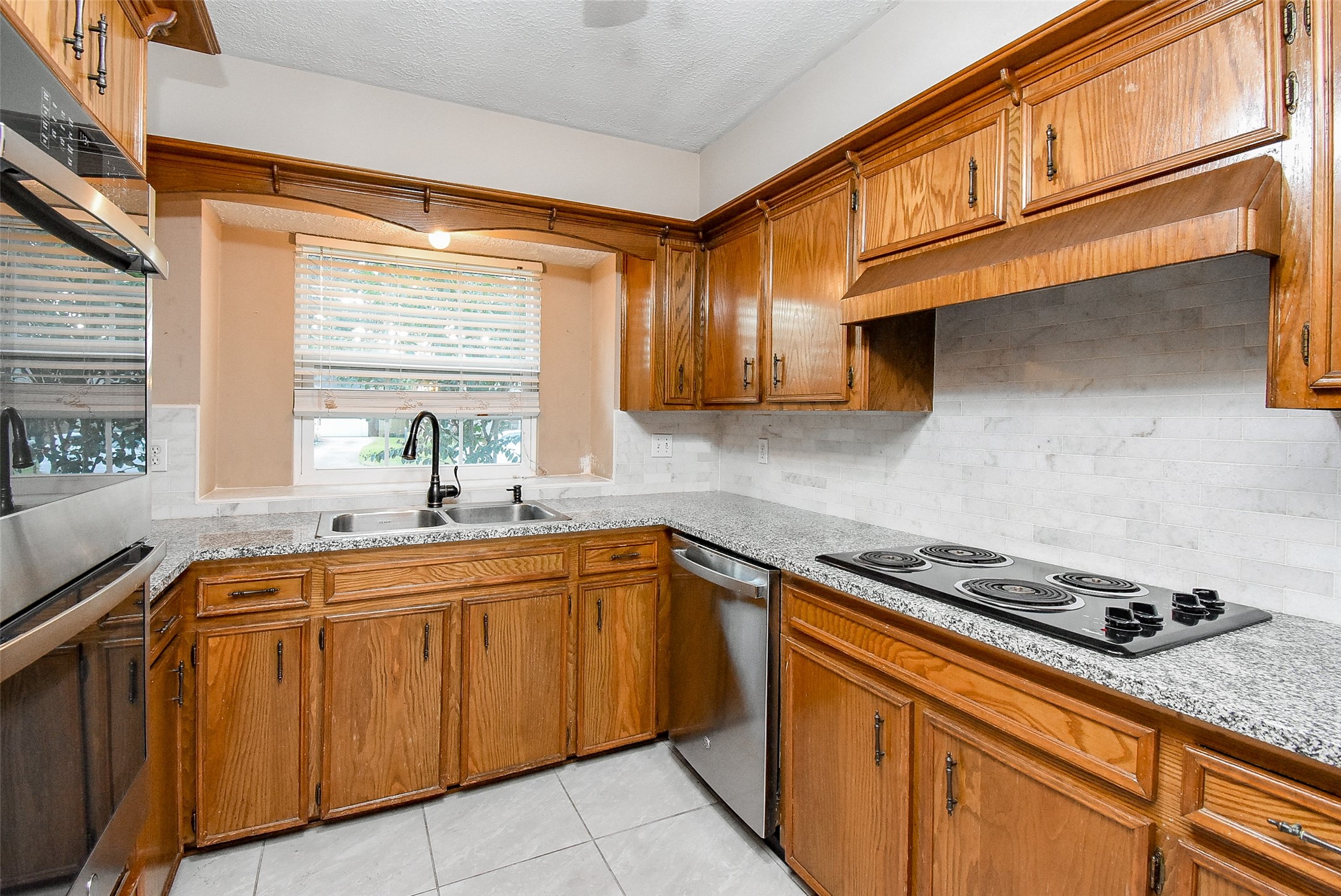 7814 Friars Ct Lane Spring, TX 77379 - Photo 8 of 17 a kitchen with stainless steel appliances granite countertop a sink stove and cabinets