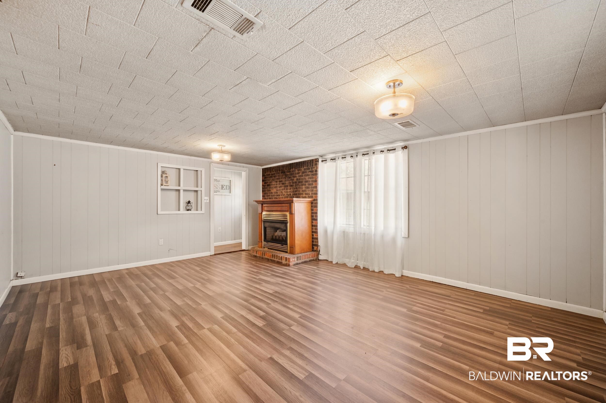 57623 Mary Hadley Road Perdido, AL 36562 - Photo 10 of 34 Unfurnished living room with wood finished floors and a brick fireplace