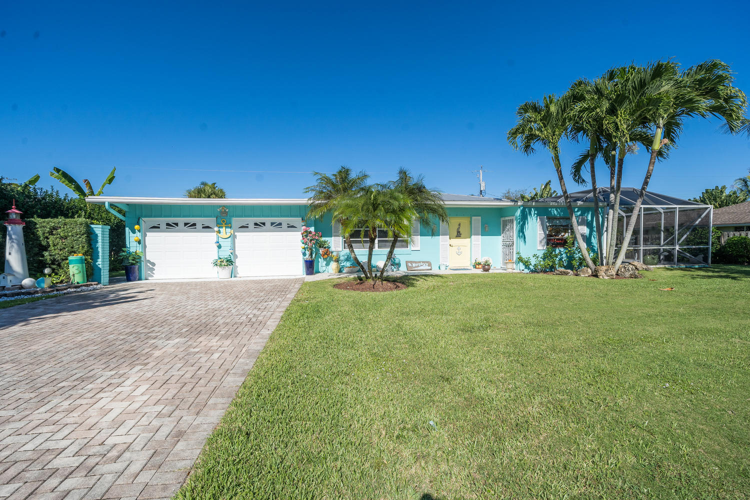 100 River Drive Tequesta, FL 33469 - Photo 2 of 54 a view of a house with a yard and a garage