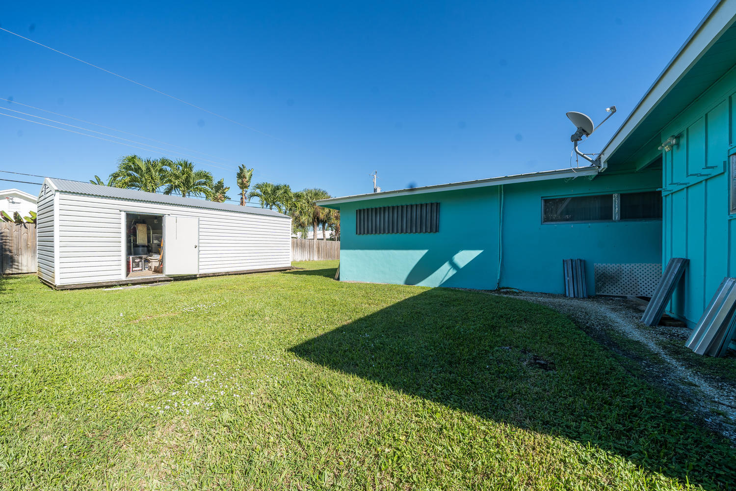 100 River Drive Tequesta, FL 33469 - Photo 34 of 54 a backyard of a house with plants and wooden fence