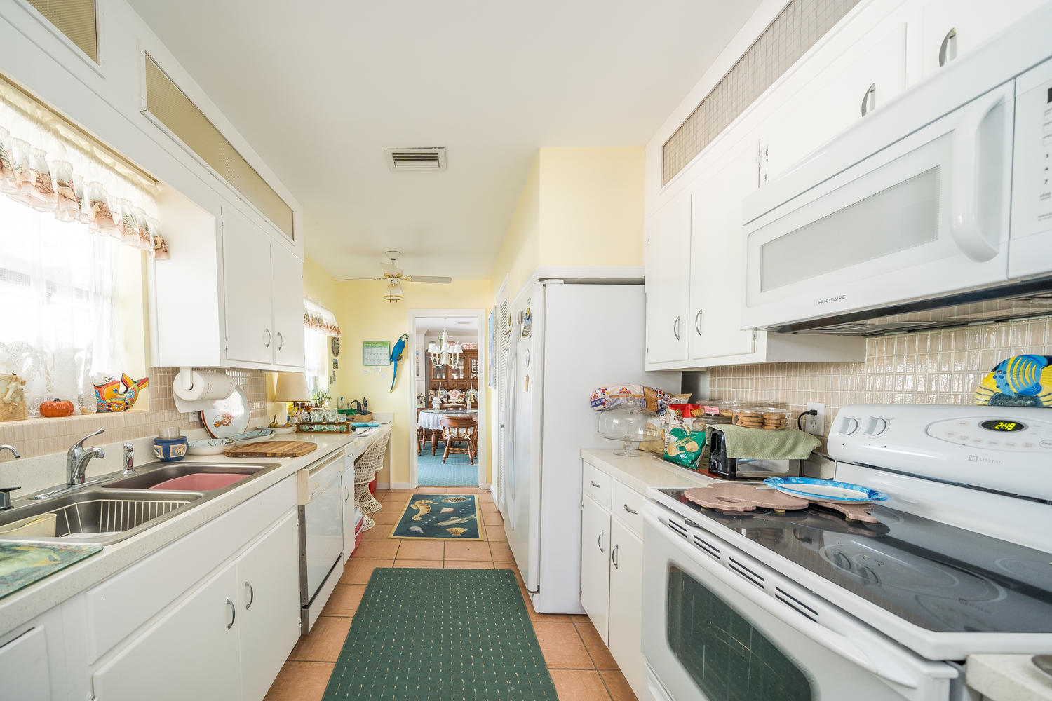100 River Drive Tequesta, FL 33469 - Photo 9 of 54 a kitchen that has a lot of cabinets a sink and appliances in it