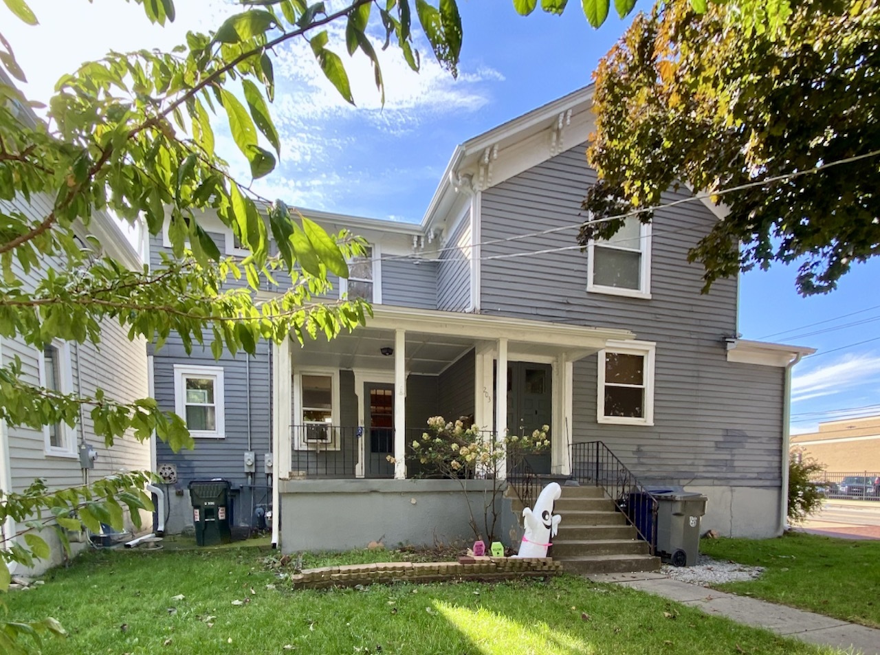 a front view of a house with a yard and a garden