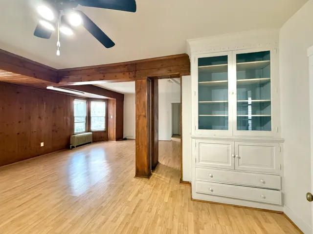 a view of an empty room with a window and fireplace