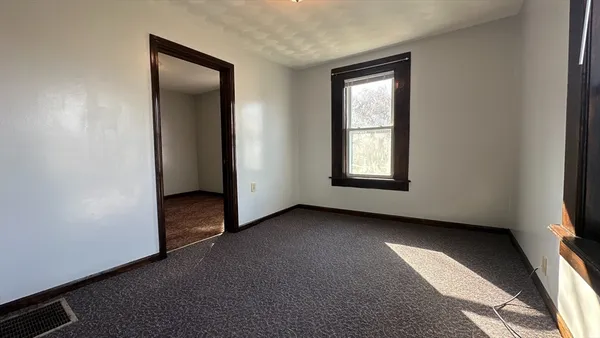 an empty room with windows and closet