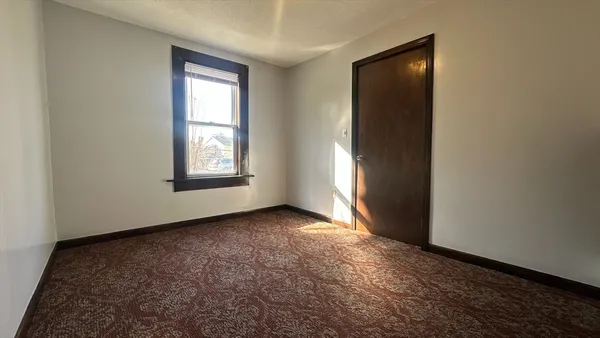 an empty room with windows and closet