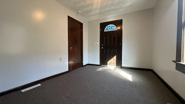 an empty room with closet and windows