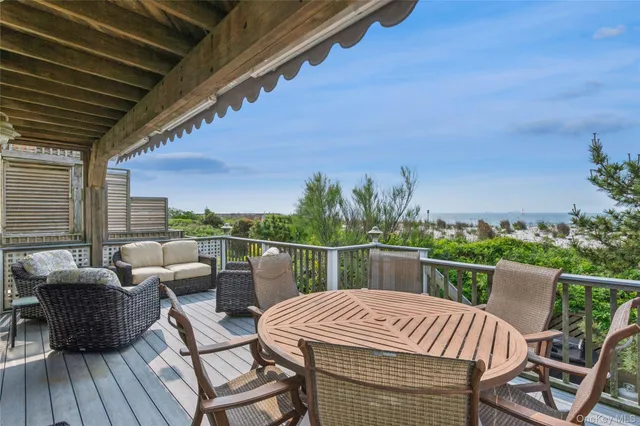 a view of patio with table and chairs potted plants and wooden fence
