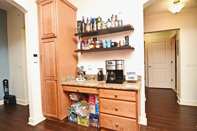 a kitchen with stainless steel appliances granite countertop a refrigerator stove and sink with wooden floor