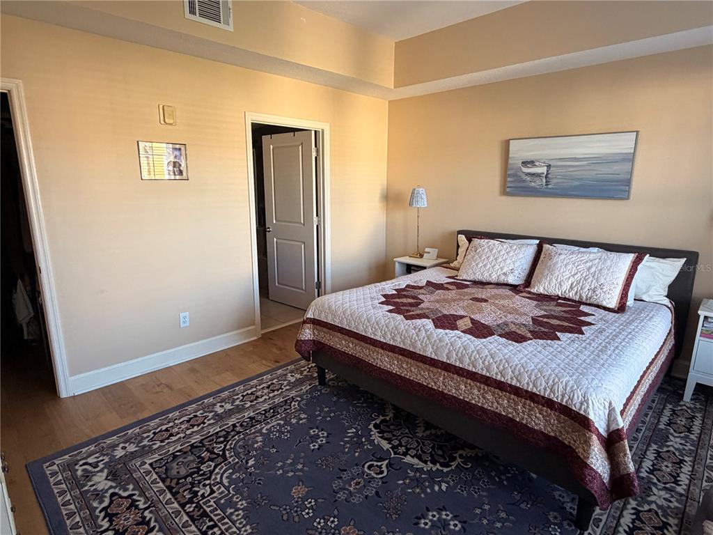 1400 Celebration Avenue, Unit 406 Celebration, FL 34747 - Photo 18 of 51 a bedroom with a bed and wooden floor