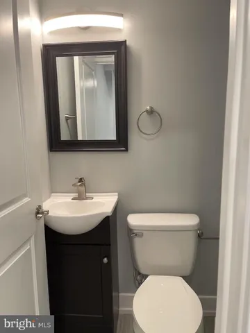a bathroom with a toilet sink and mirror
