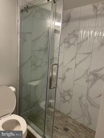 a bathroom with a toilet and a shower