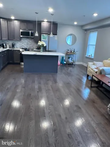 a living room with kitchen island furniture and a wooden floor